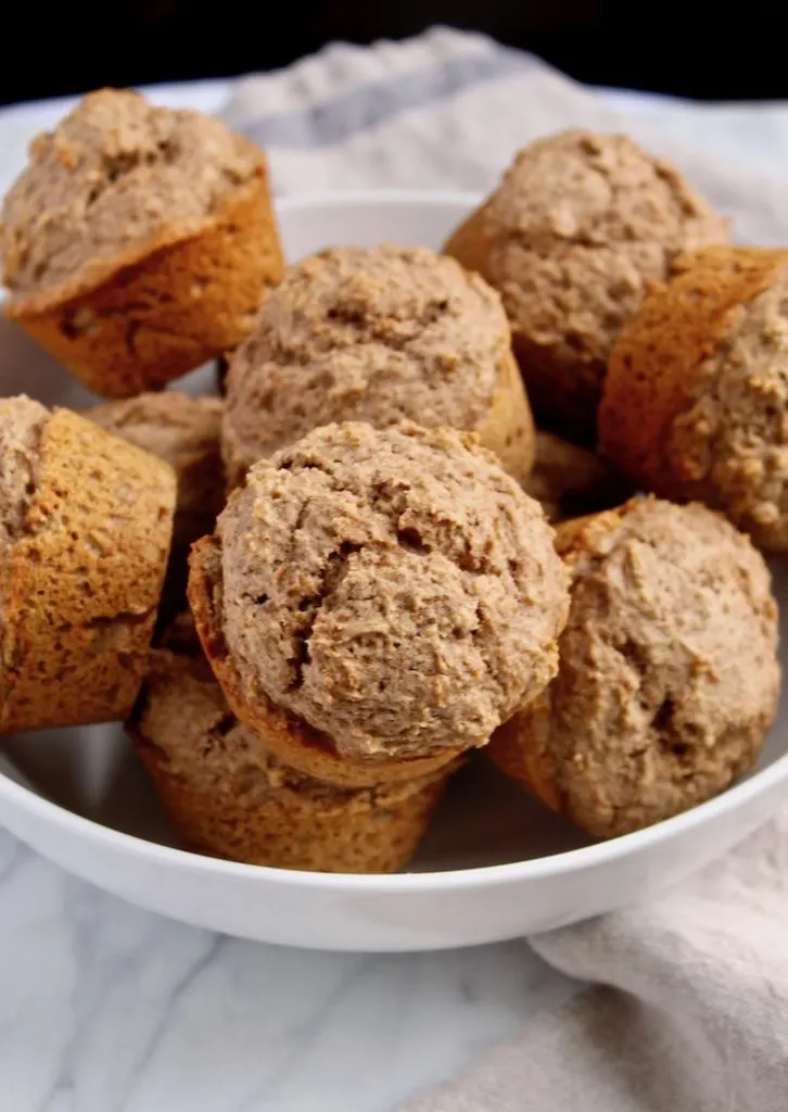 Muffins piled in white bowl.