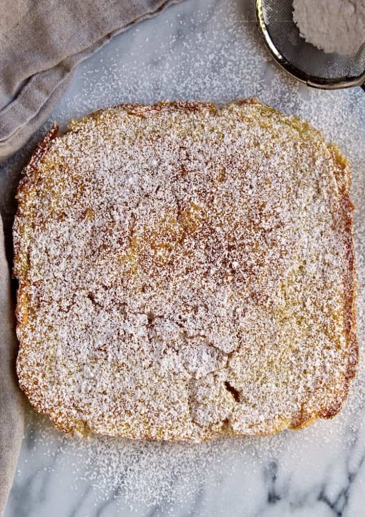 Lemon Squares, overhead on marble board, just out of pan with powdered sugar.