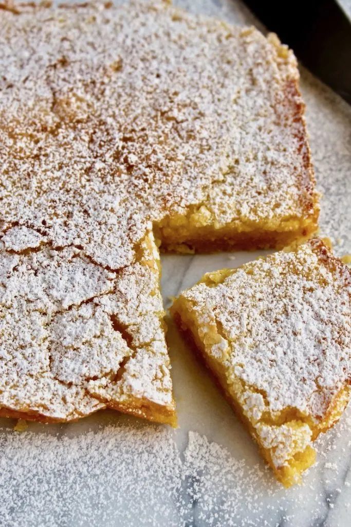 Lemon Squares, on marble board with corner piece cut.