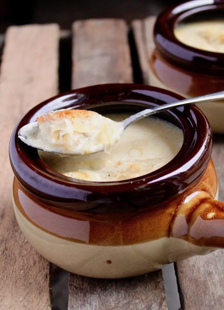 Irish Beer Cheese Soup, close up in serving bowl with spoonful od soup.