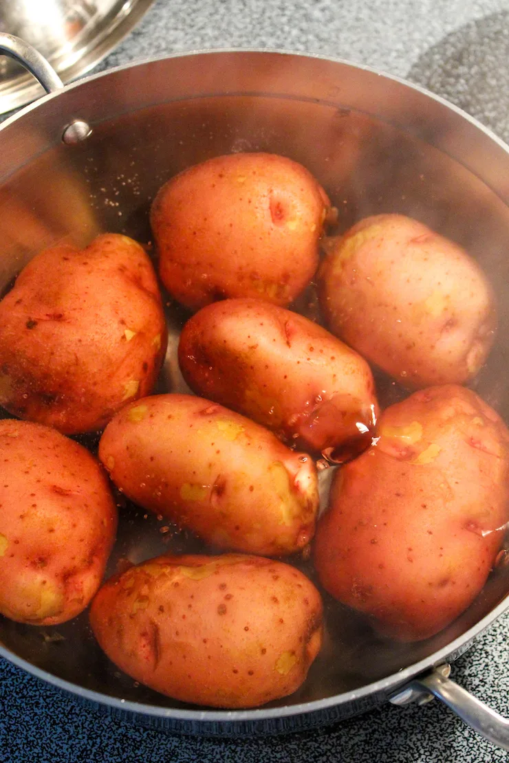 Red potatoes boiling in pot.