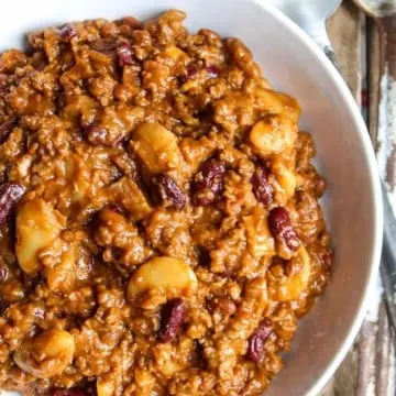 Hamburger baked beans in white serving dish.