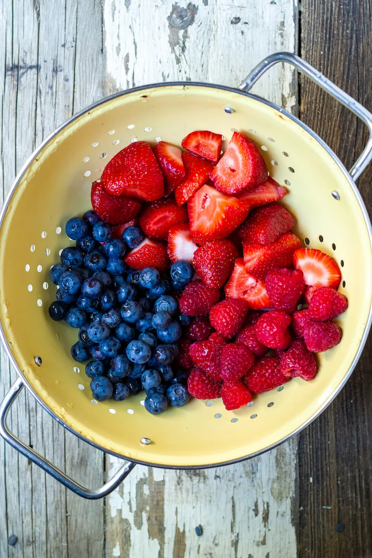 Mixed berried in yellow colander.