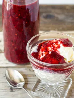 Balsamic berry sauce over ice cream, sauce in bottle in background.