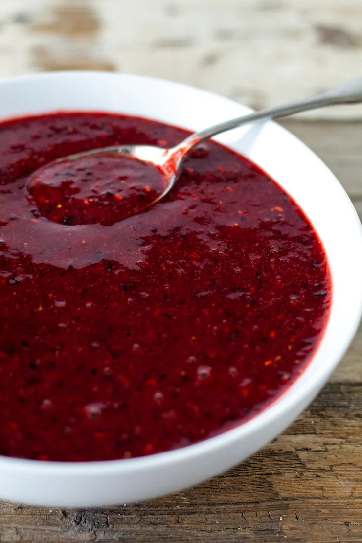 Balsamic berry sauce in white bowl with spoon.