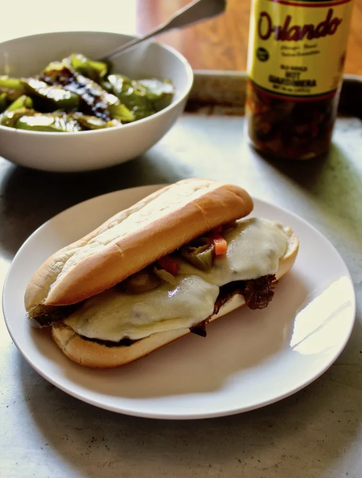 Italian Beef Po' Boys, on plate with peppers in background.