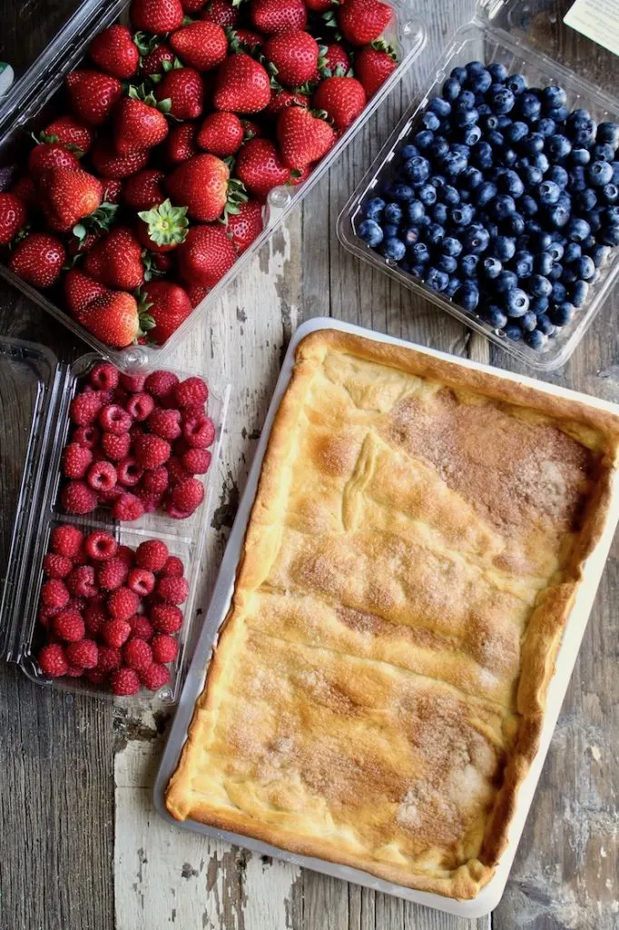 Red, White & Blue Fruit Pizza ingredients, fresh berries and crust in pan.