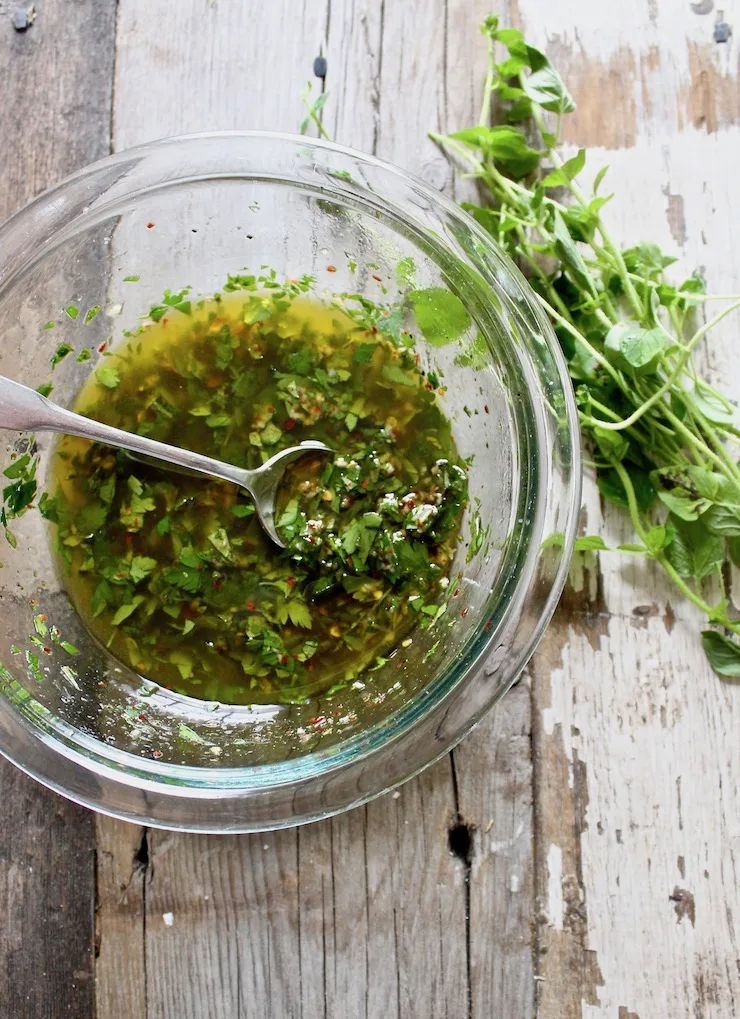 Chimichurri Sauce in mixing bowl with spoon.
