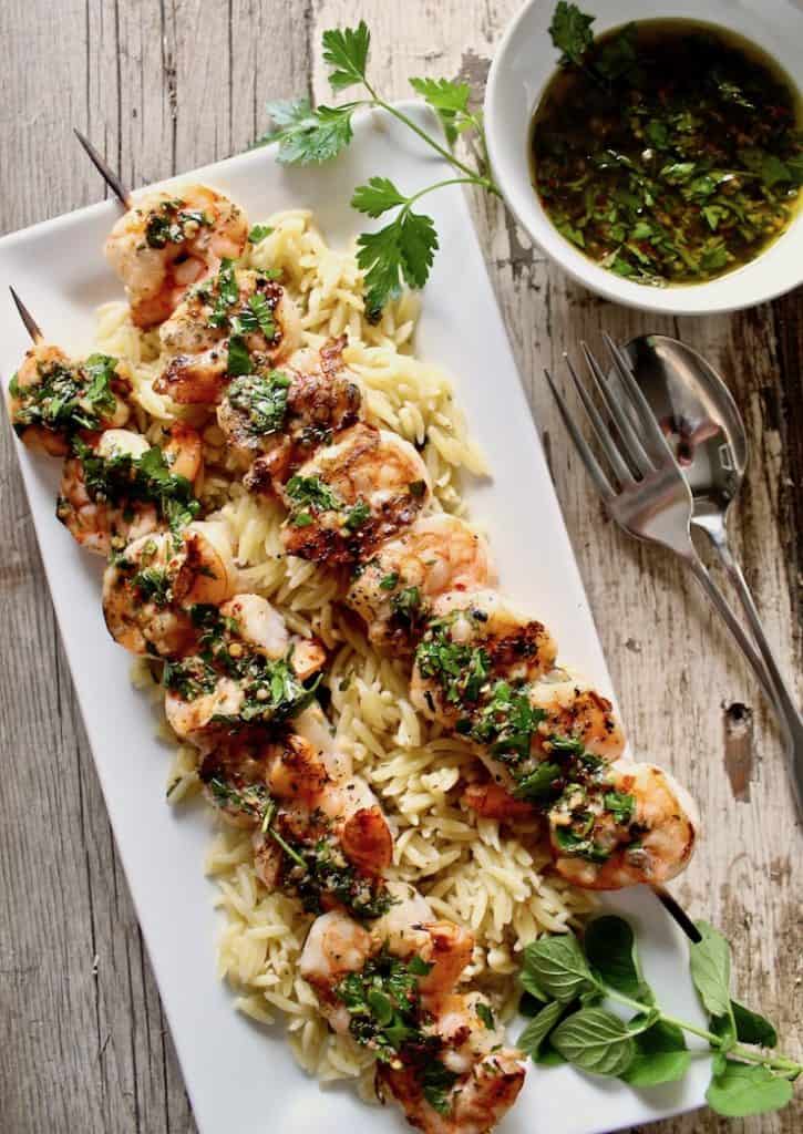 Grilled Shrimp skewers on p;atter with Chimichurri Sauce