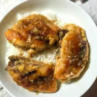 Chicken breast on white plate with rice.