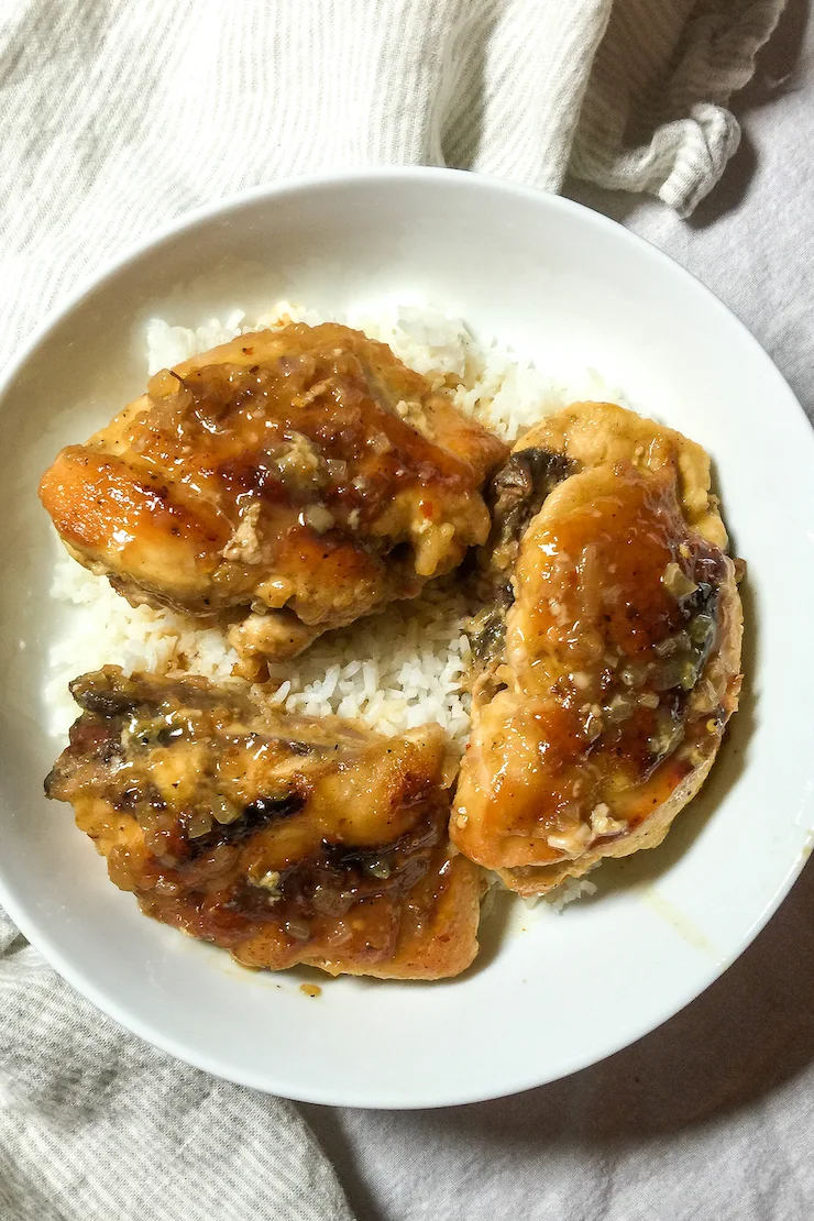 Chicken breast on white plate with rice.