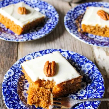 Pumpkin bars on several blue plates with pecan on top.