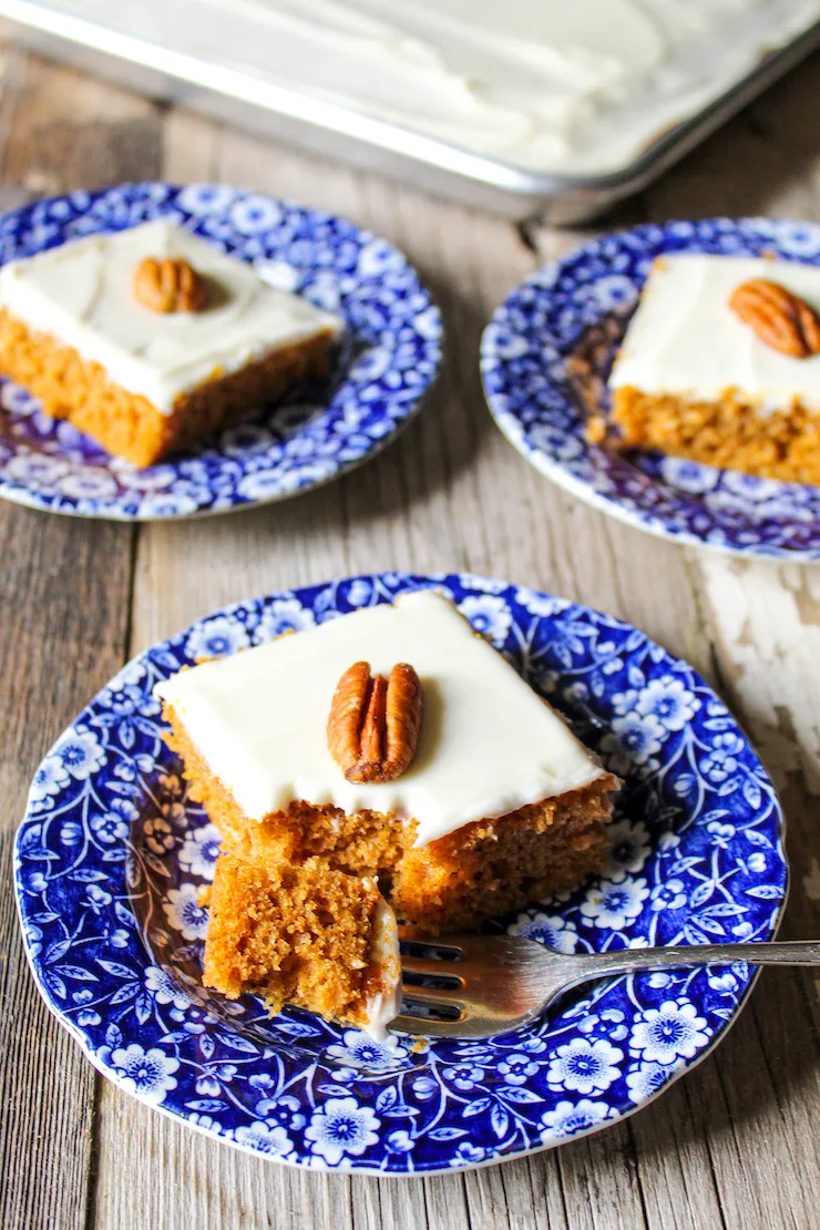 Pumpkin bars on several blue plates with pecan on top.