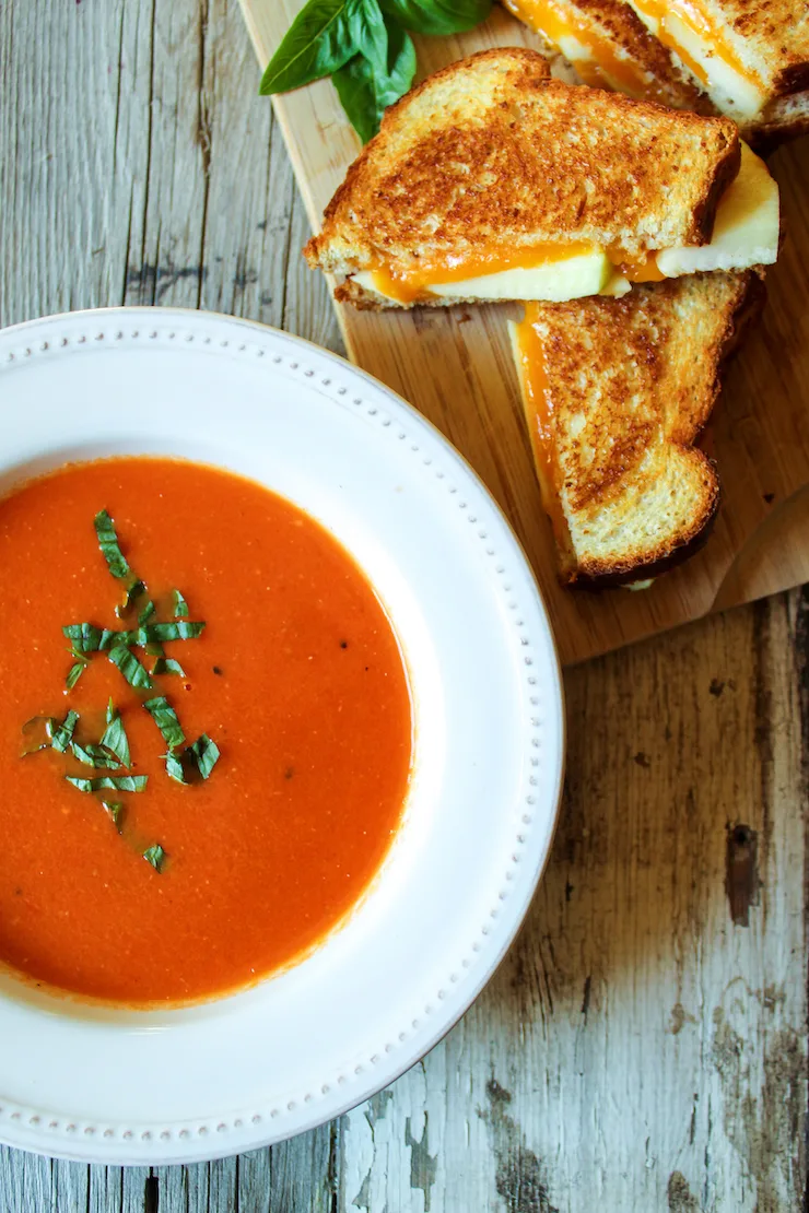Bowl of soup and grilled cheese on the side.