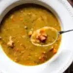 Soup in bowl with spoonful raised above.