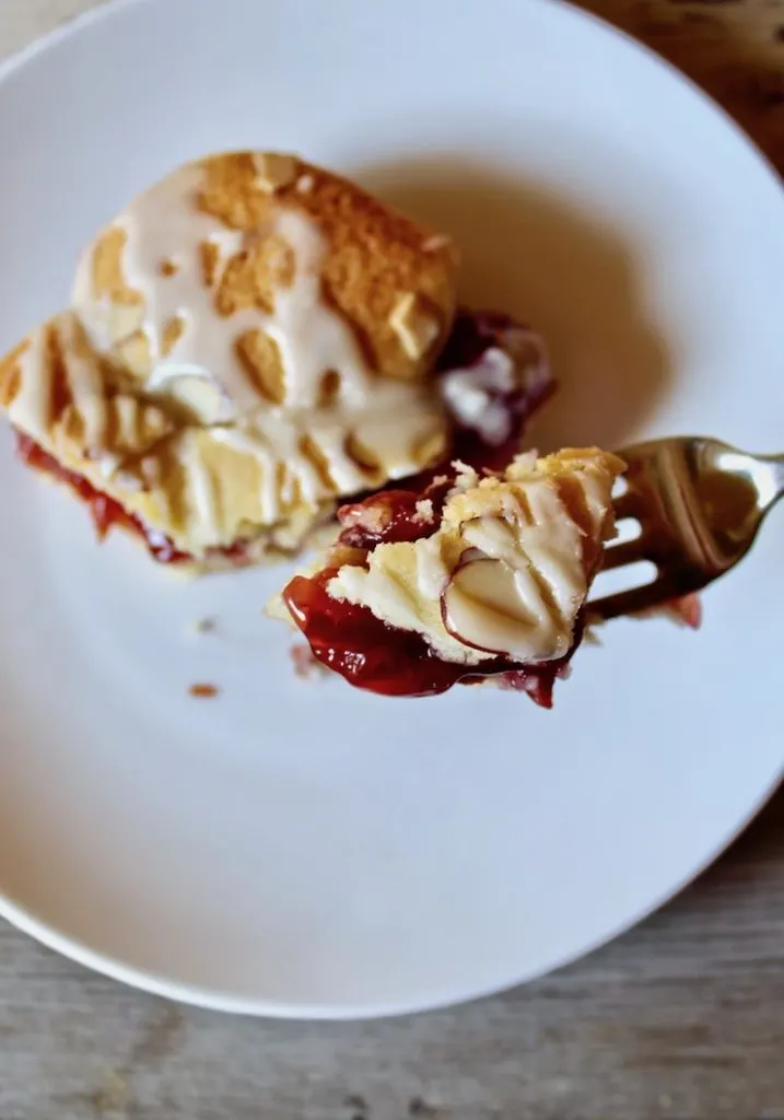 On plate with forkful of cherry pie bar.