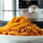 Pin for Pinterest with text, plate of spaghetti in front of pressure cooker