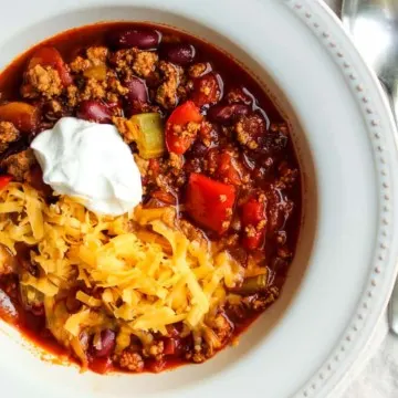 Turkey chili in bowl with sour cream and cheese.