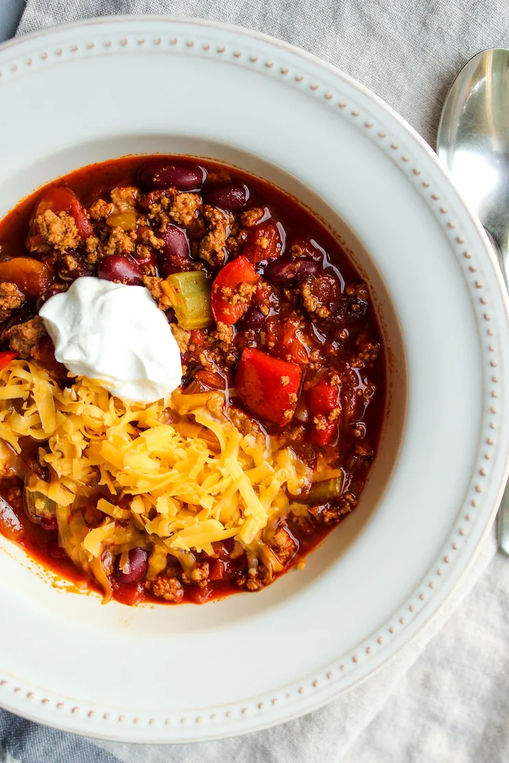 Turkey chili in bowl with sour cream and cheese.