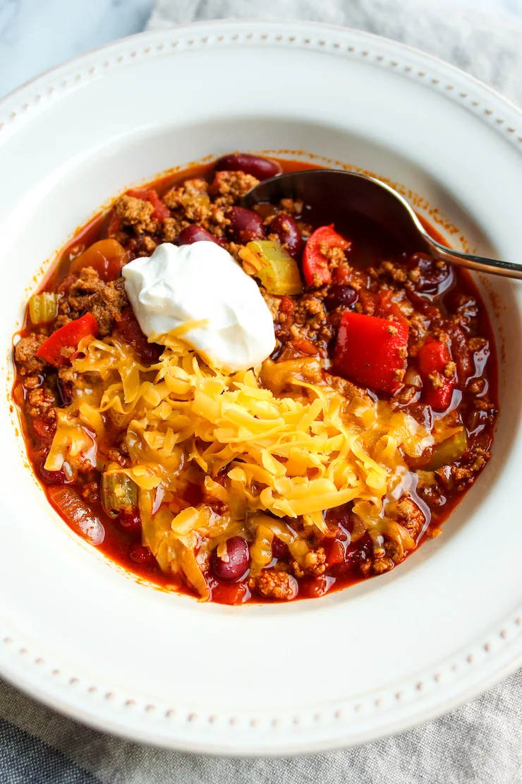 Turkey chili in serving bowl with toppings.