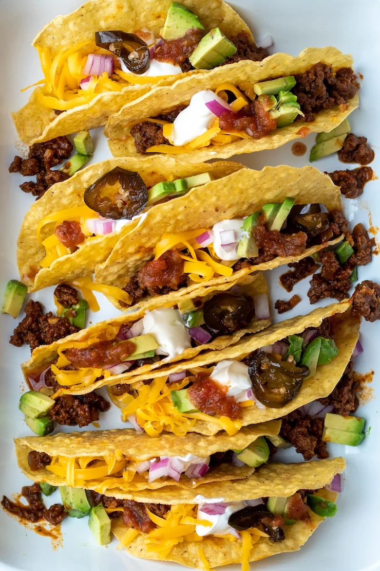 Closeup of beef tacos with toppings.