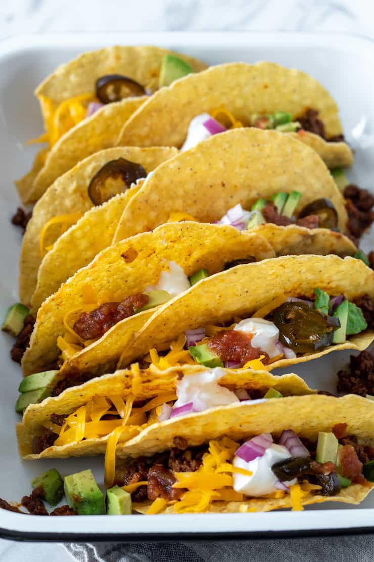 Assembled beef tacos with toppings.