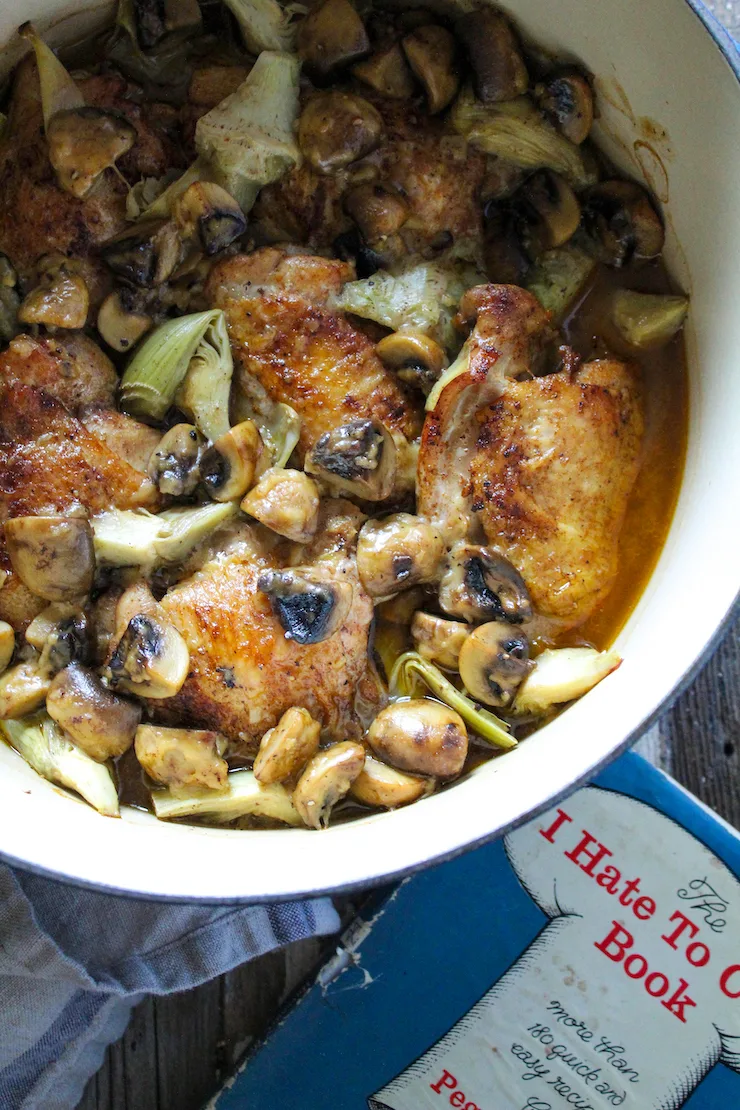 Close up of chicken dish and cookbook.