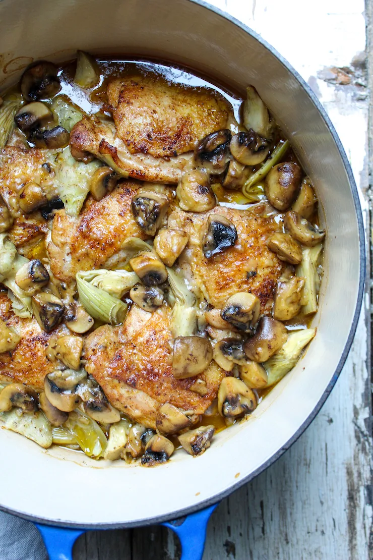 Chicken with artichokes and mushrooms in Dutch oven.