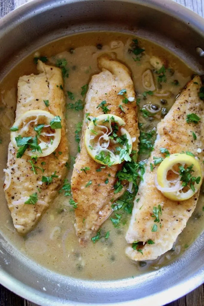 Finished tilapia in pan sauce with lemons