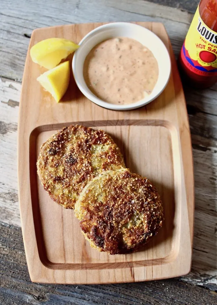 On serving board with remoulade sauce, lemons and hot sauce