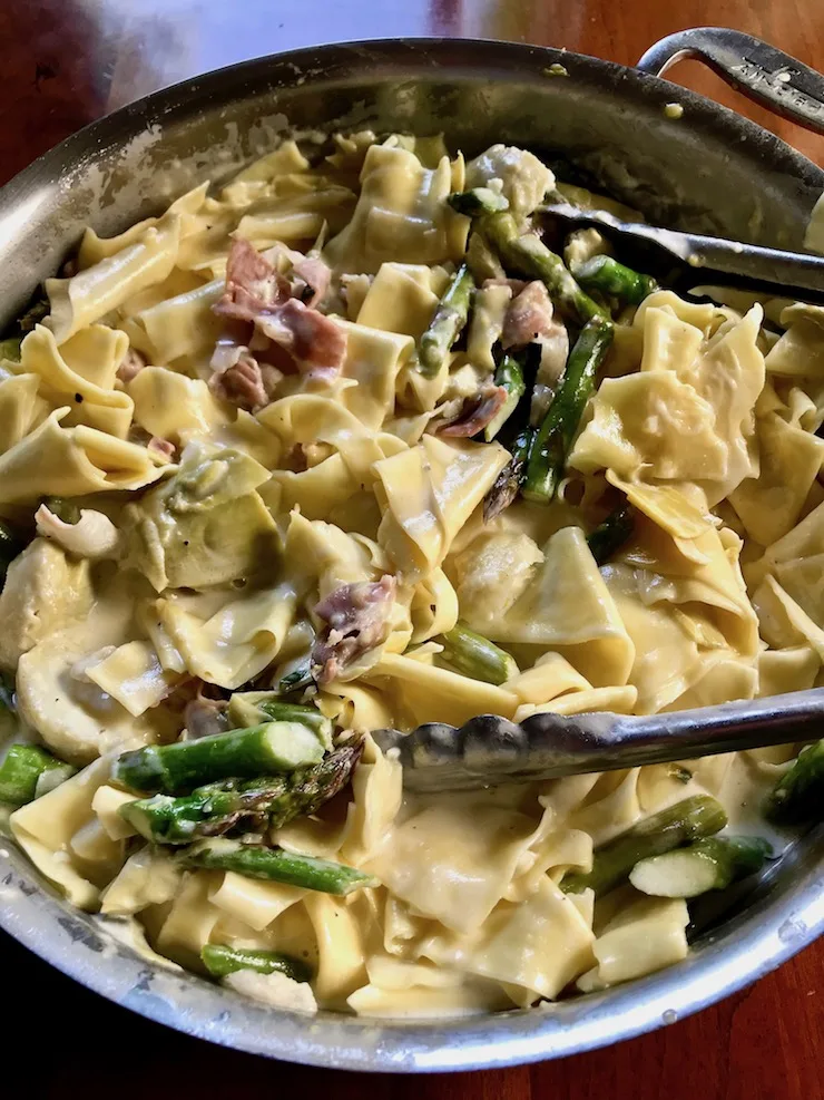 Overhead shot of Pasta with Asparagus and Prosciutto with tongs