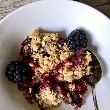 Fresh Blackberry Crisp closeup in a white bowl.