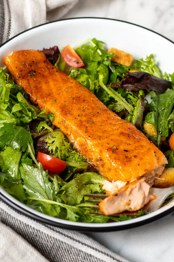 Cajun brown sugar salmon plated with salad greens.