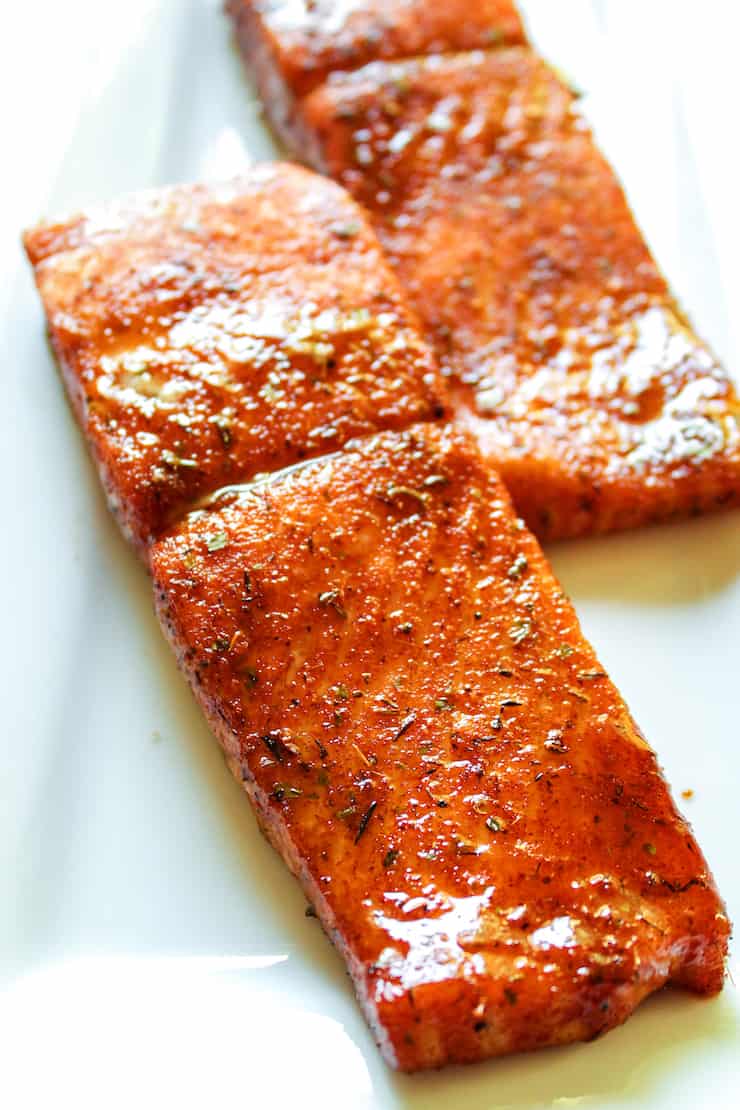 Baked Cajun salmon on white platter.
