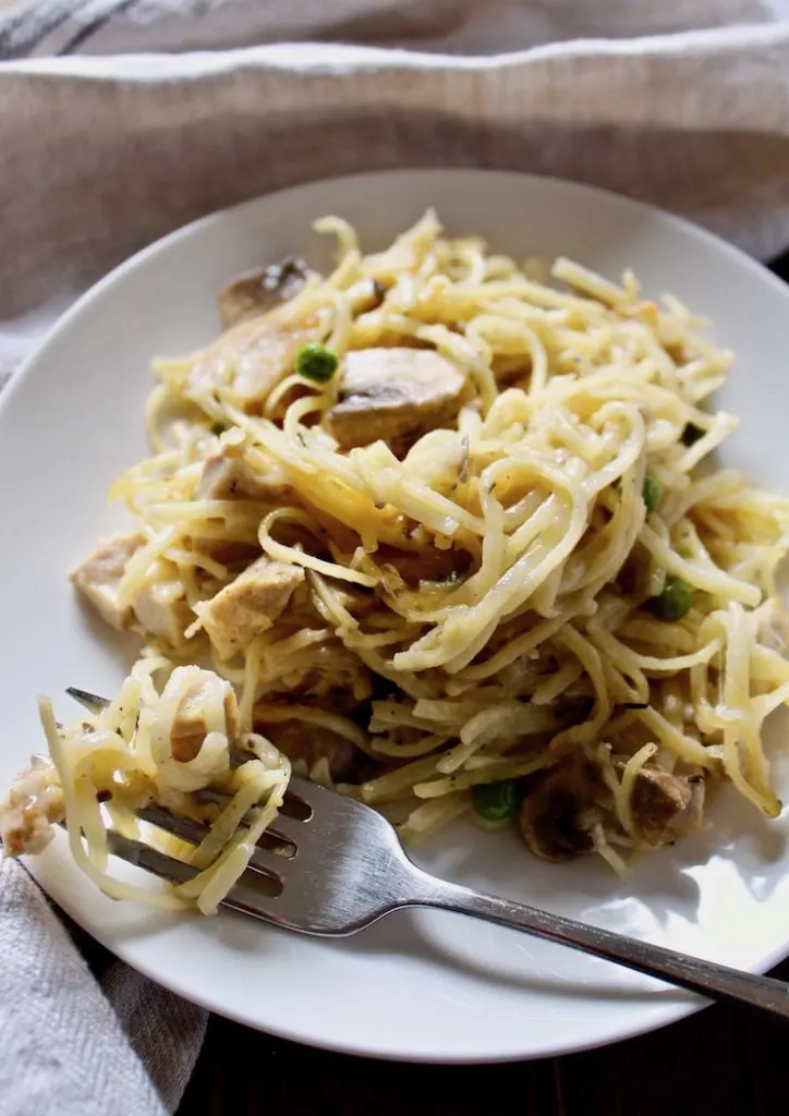 On serving plate with fork full of linguine.