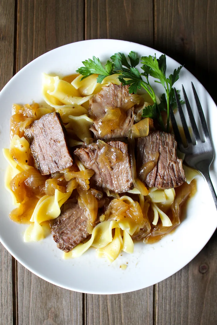 Beer braised beef and onions over egg noodles with fork