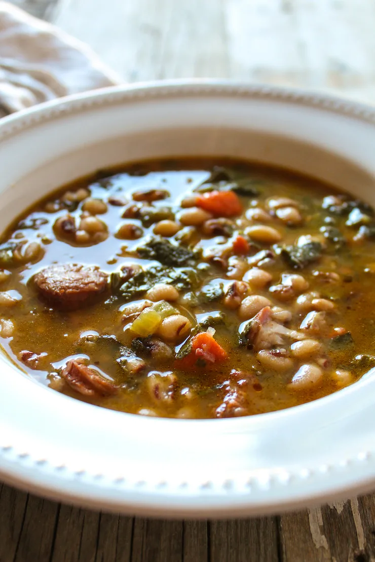 Black eyed pea soup and collard greens in serving bowl.