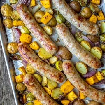 Cooked sausage and vegetables on sheet pan.