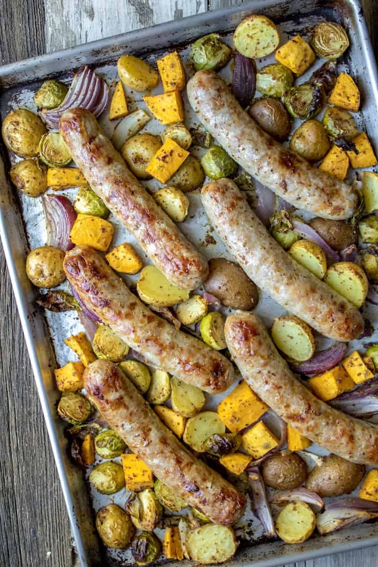 Cooked sausage and vegetables on sheet pan.