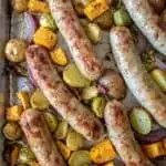 Sausages and caramelized vegetables on sheet pan.