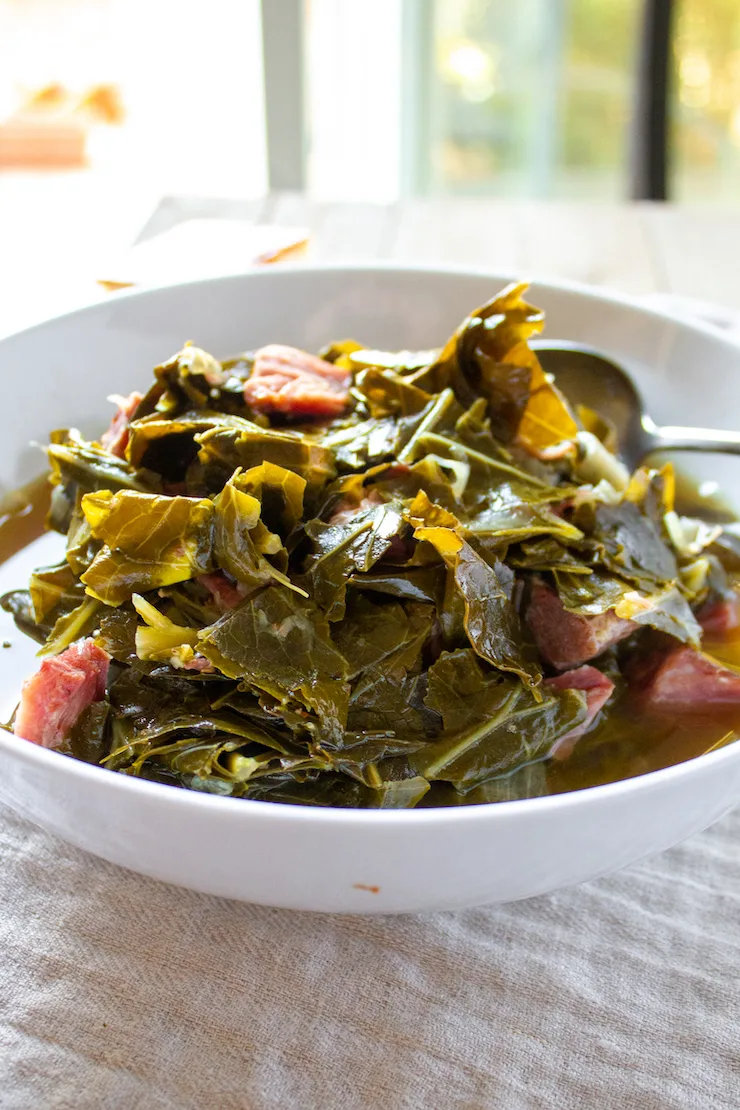 Collard greens in white serving bowl.