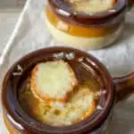 French Onion Soup, in serving bowls with melted cheese on top.