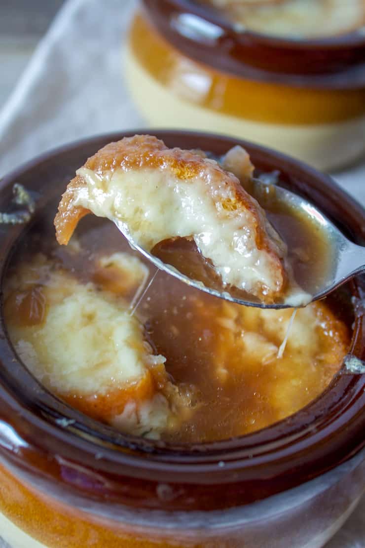 Spoonful of soup with crouton and cheese.