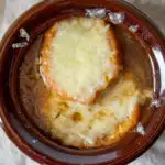 French Onion Soup, close up in oven proof bowl with melted cheese.