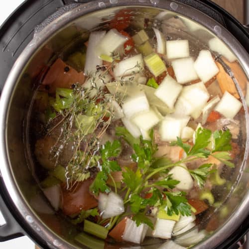 Instant Pot Chicken Stock, ingredients in insert ready to seal and pressure cook.