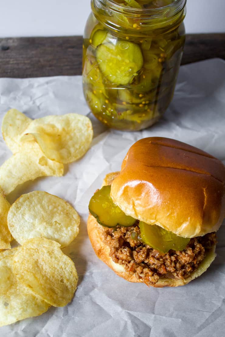 Sloppy joe sandwich with pickles and potato chips