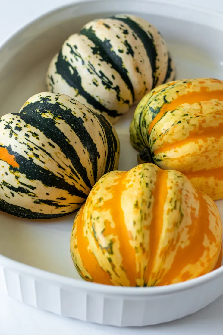 Carnival squash variety cut side down in baking dish.