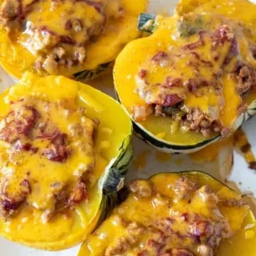 Baked stuffed acorn squash with melted cheese.