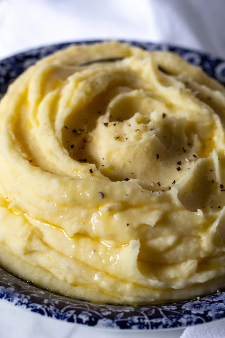 Garlic buttermilk mashed potatoes in blue serving bowl.