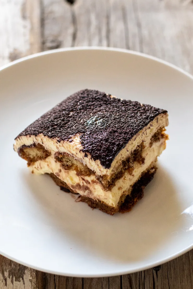 Overhead shot of slice of tiramisu on white plate